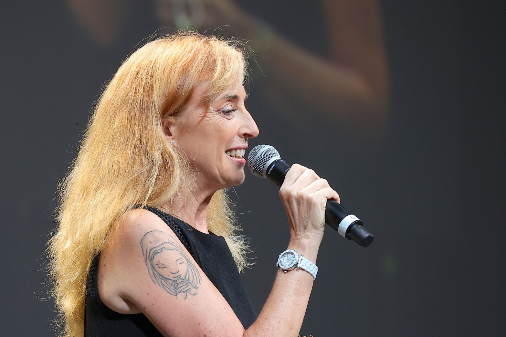 Anne-Marie de Couvreur sur scène, micro en main